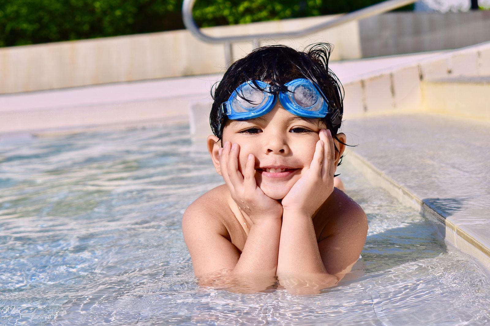 Enfant souriant au bord d'une piscine